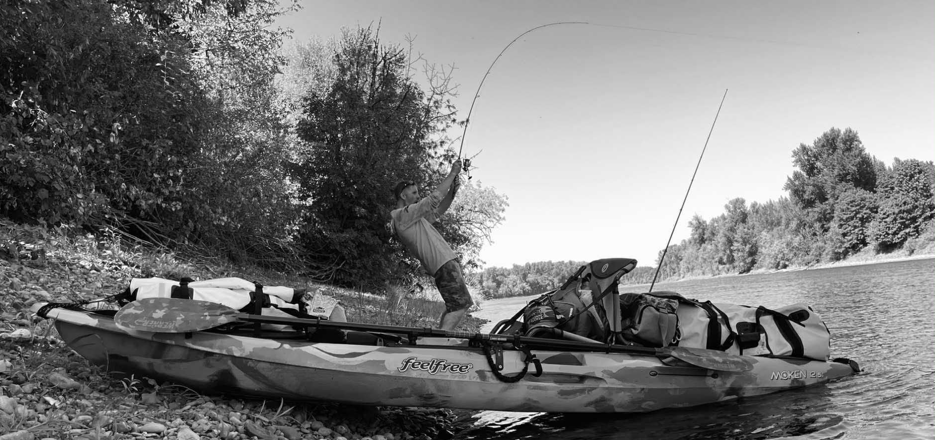 Jeff fishing beside a kayak on a river